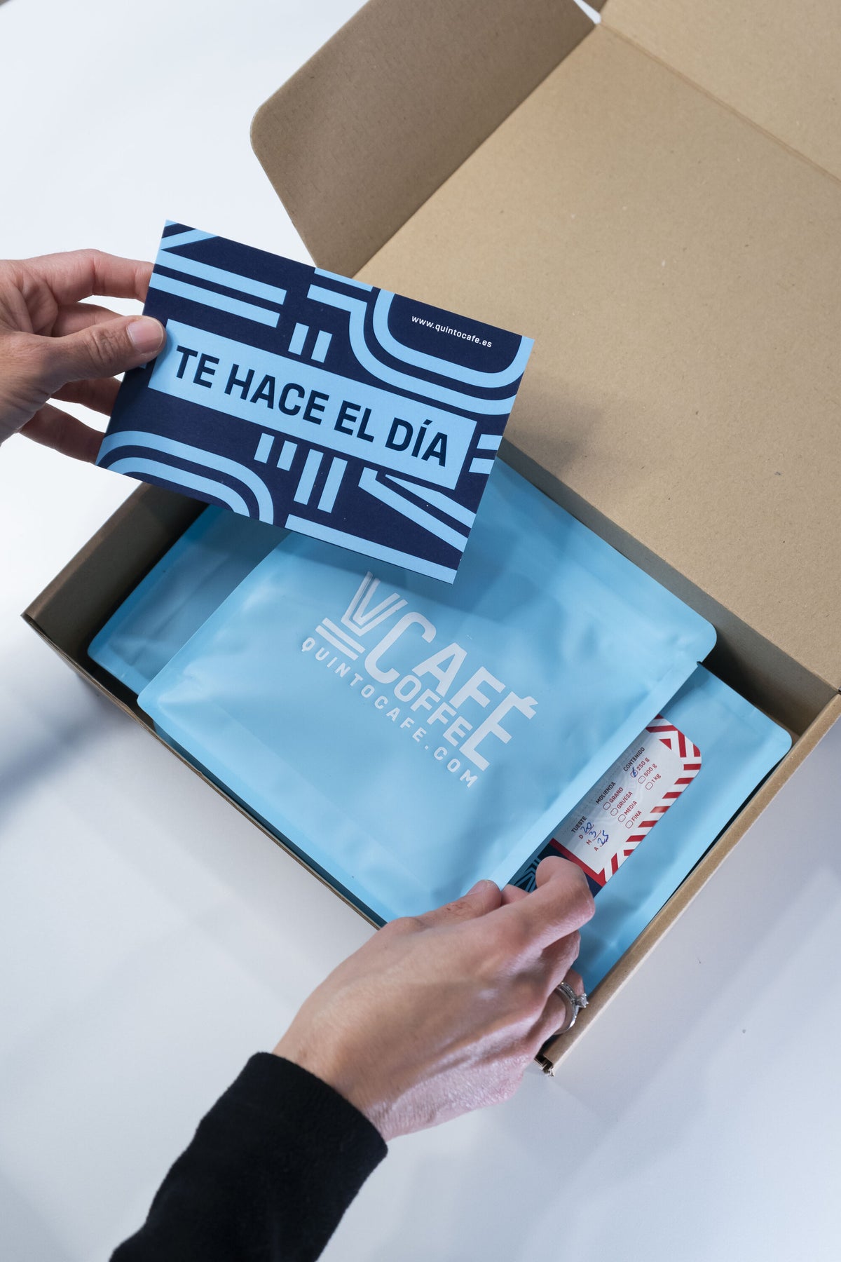 Caja de suscripción Quinto Café con la tarjeta Te hace el día y bolsas de café
